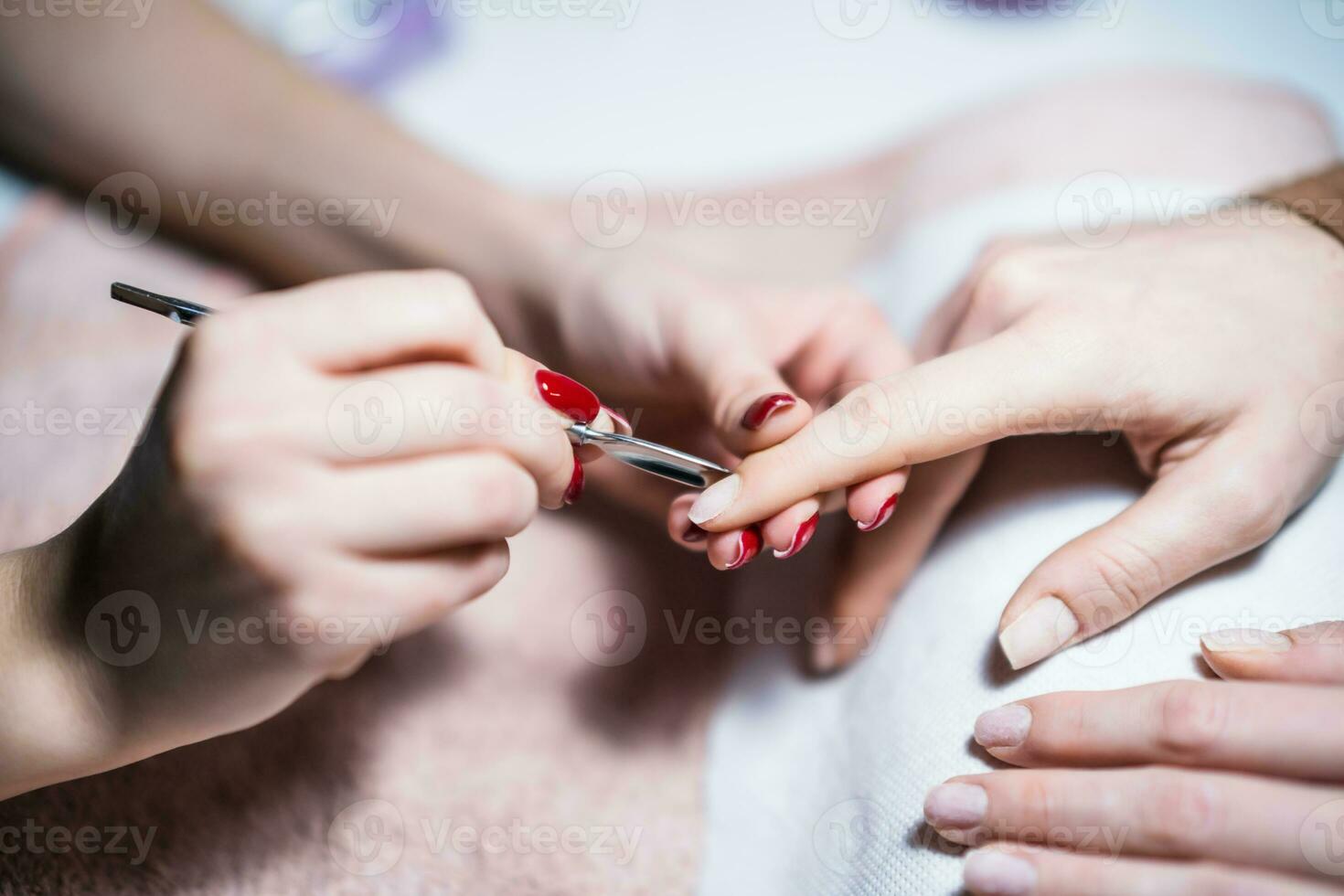 fechar acima imagem do manicure processo, remoção do excesso pele em a unha com uma especial ferramenta. foco em unha da mão. foto