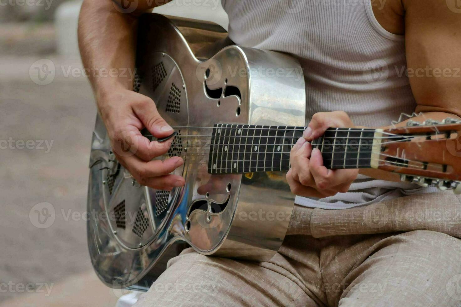 uma homem jogando a acústico guitarra em a rua foto