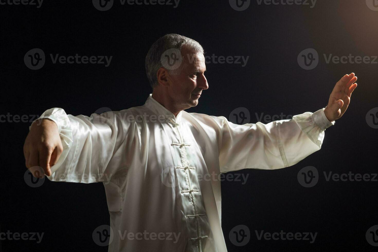 Senior homem goza exercício tai chi interior foto