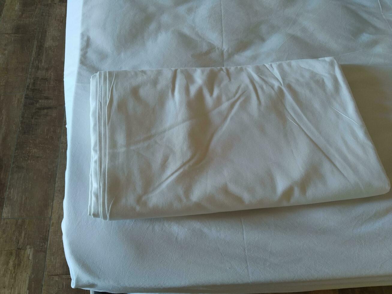 branco roupa de cama folhas e almofadas em uma cama dentro a quarto foto