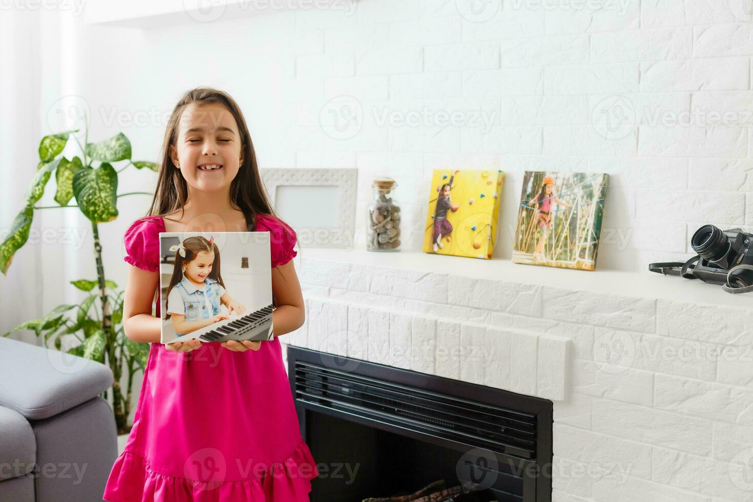 fofa pequeno menina segurando foto tela de pintura às casa