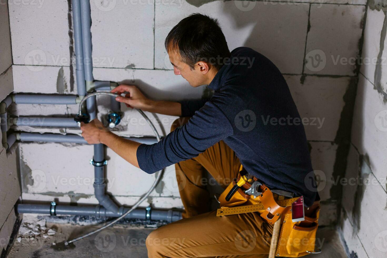 fechar-se do uma masculino encanador reparos tubos dentro a banheiro foto