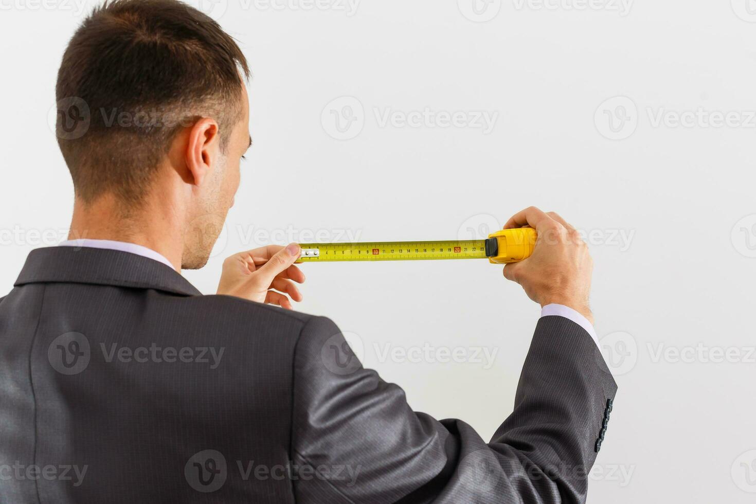 homem de negocios segurando medição fita, isolado em branco fundo foto