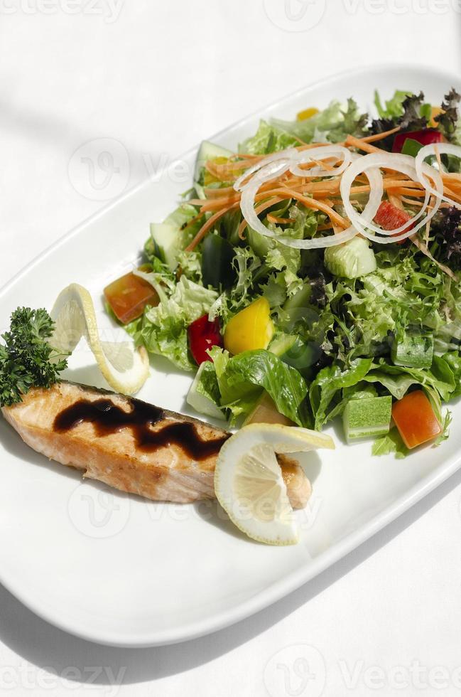 Salada orgânica de vegetais mistos com filé de salmão e vinagrete balsâmico foto