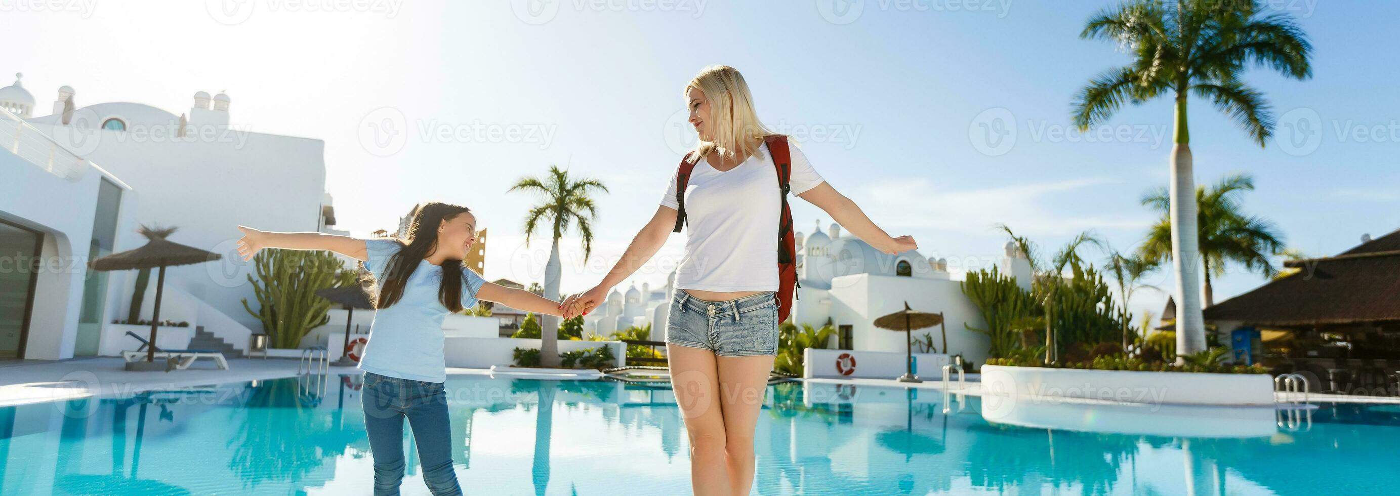 menina caminhando com mãe às à beira da piscina. mãe filha caminhando de a piscina foto