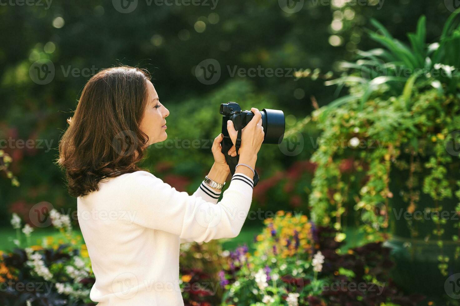 ao ar livre retrato do lindo mulher levando As fotos com sem espelho Câmera dentro verde jardim