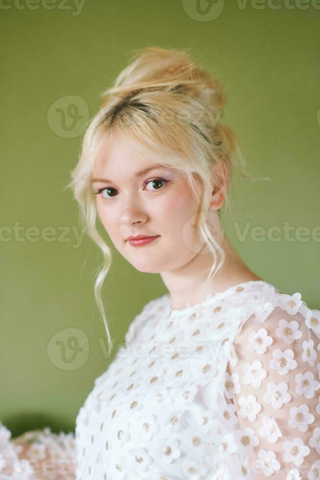 beleza retrato do bonita jovem 15 - 16 ano velho adolescência menina vestindo branco vestir posando em verde fundo foto