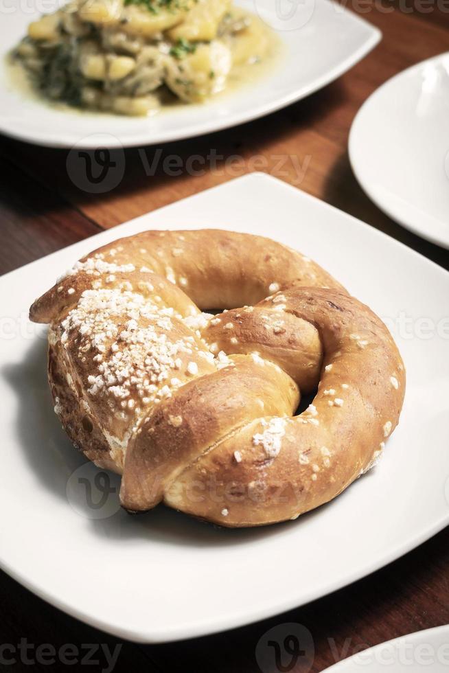 Pão de pretzel alemão orgânico sem laticínios vegano na mesa de madeira foto