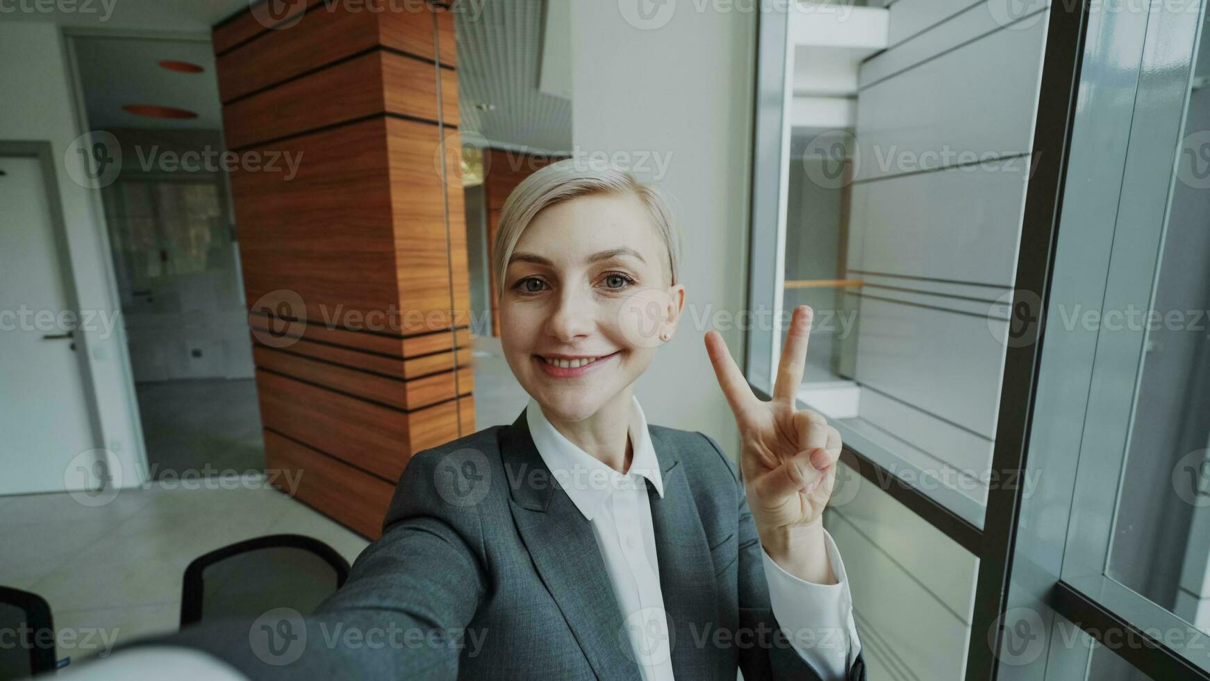 pov do jovem empresária dentro terno levando uma selfie foto segurando Smartphone e ter Diversão dentro moderno escritório dentro de casa