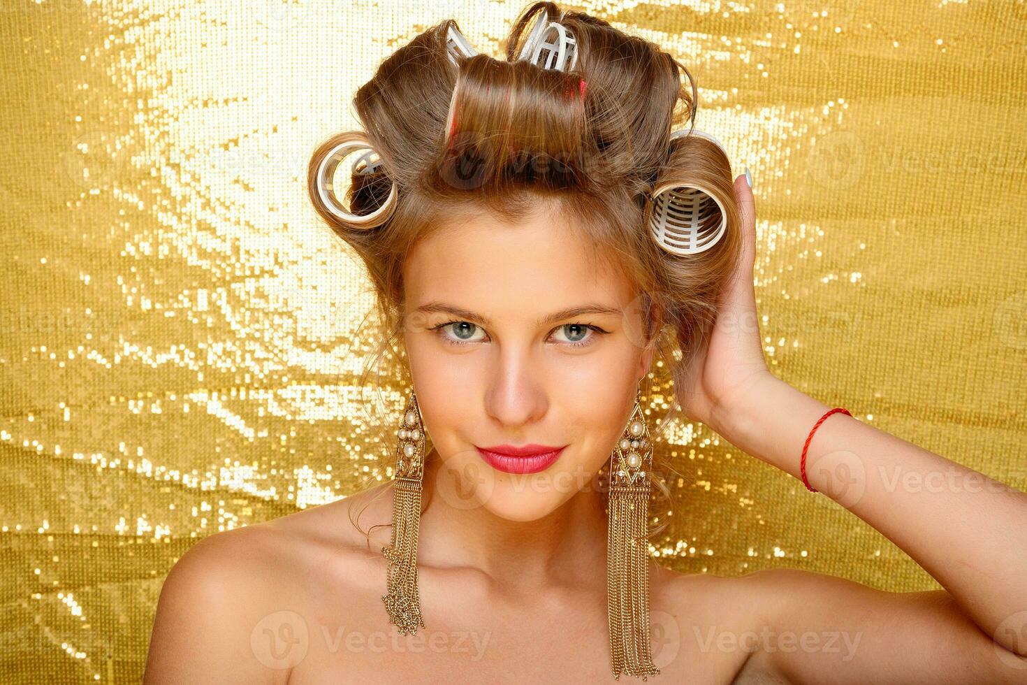 lindo menina dentro cabelo bobes isolado em ouro foto