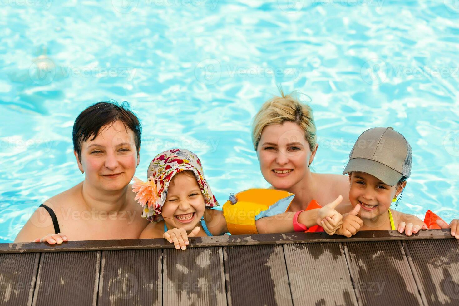 dois mulheres e seus crianças dentro a piscina foto