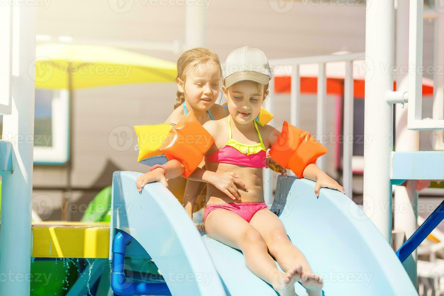 dois pequeno meninas jogando dentro a piscina foto