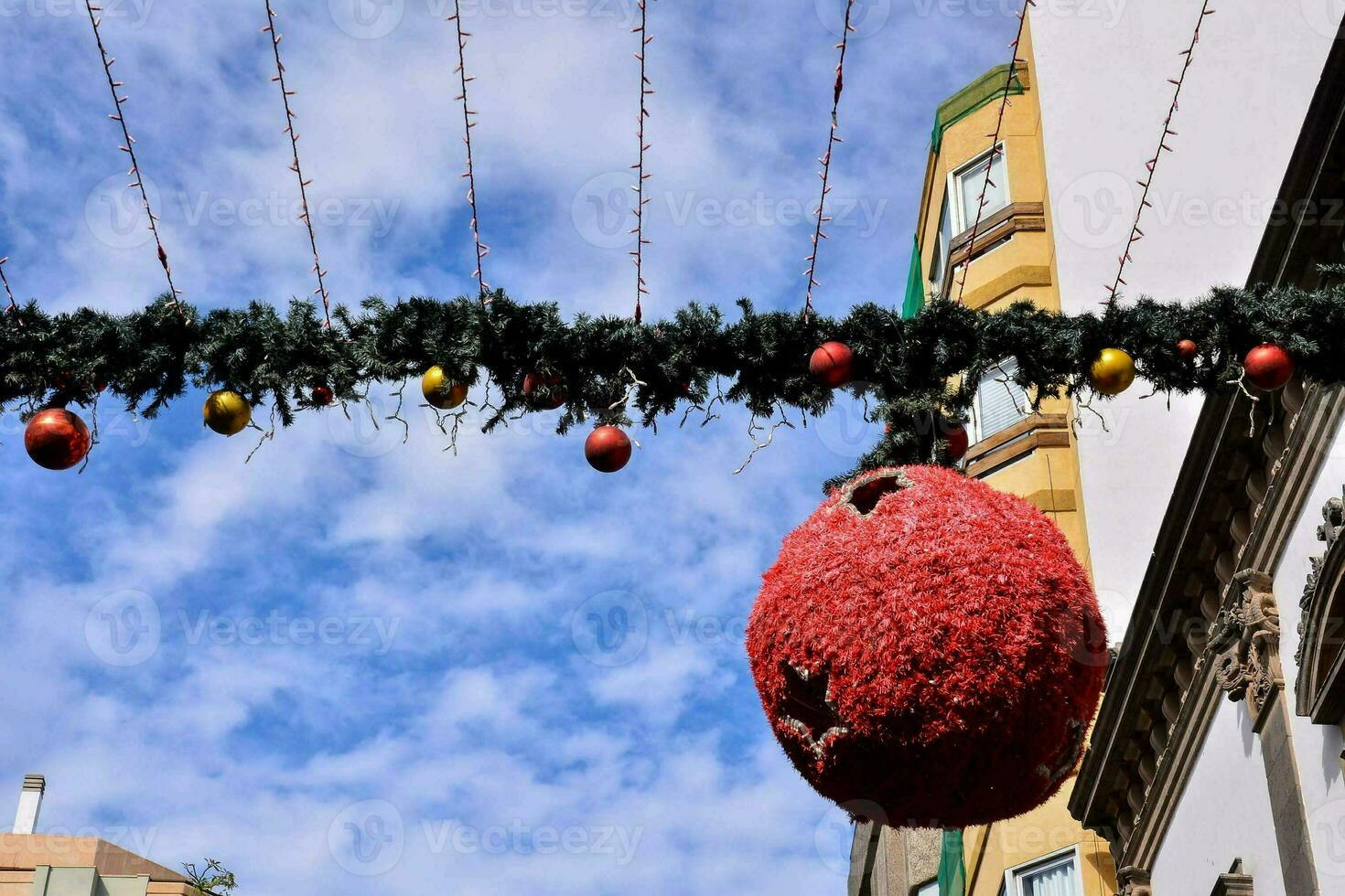 uma vermelho bola suspensão a partir de uma corda com Natal decorações foto