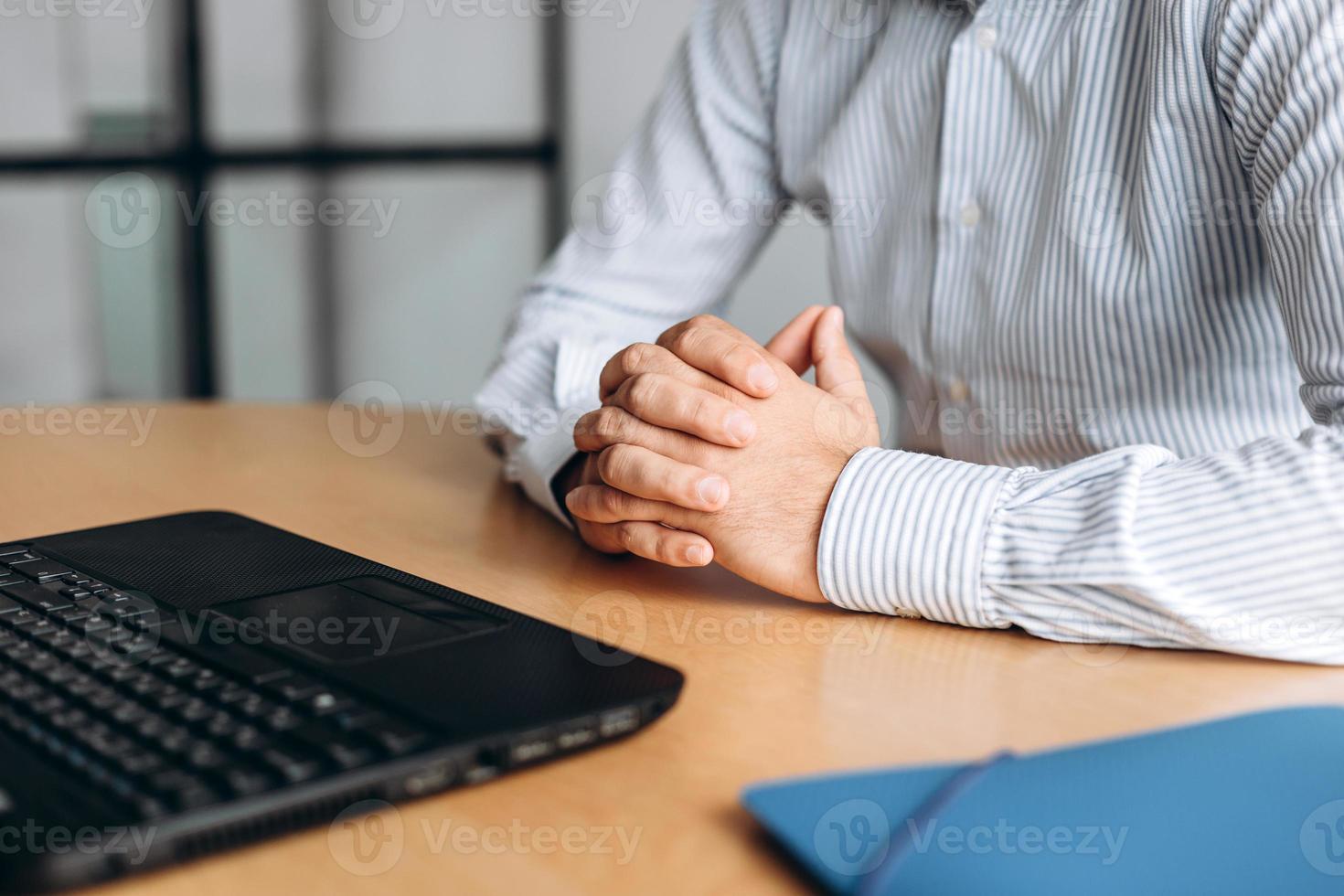 empresário com as mãos na mesa, trabalhando no computador foto