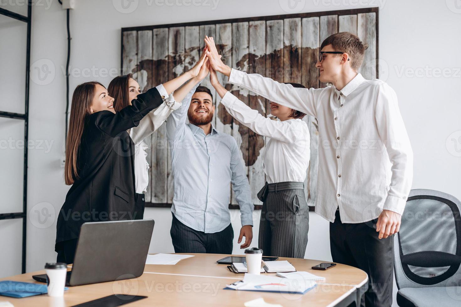 empresários felizes mostrando o trabalho em equipe e dando cinco após a assinatura de um acordo ou contrato com parceiros no interior do escritório. pessoas felizes sorrindo. acordo ou conceito de contrato. - imagem foto