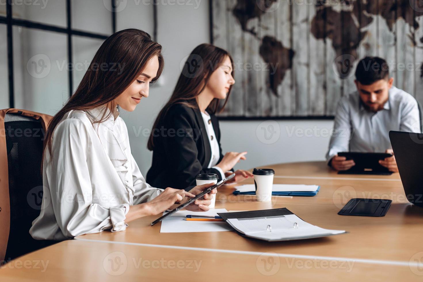 menina bonita trabalhando em um tablet, na mesa. foto