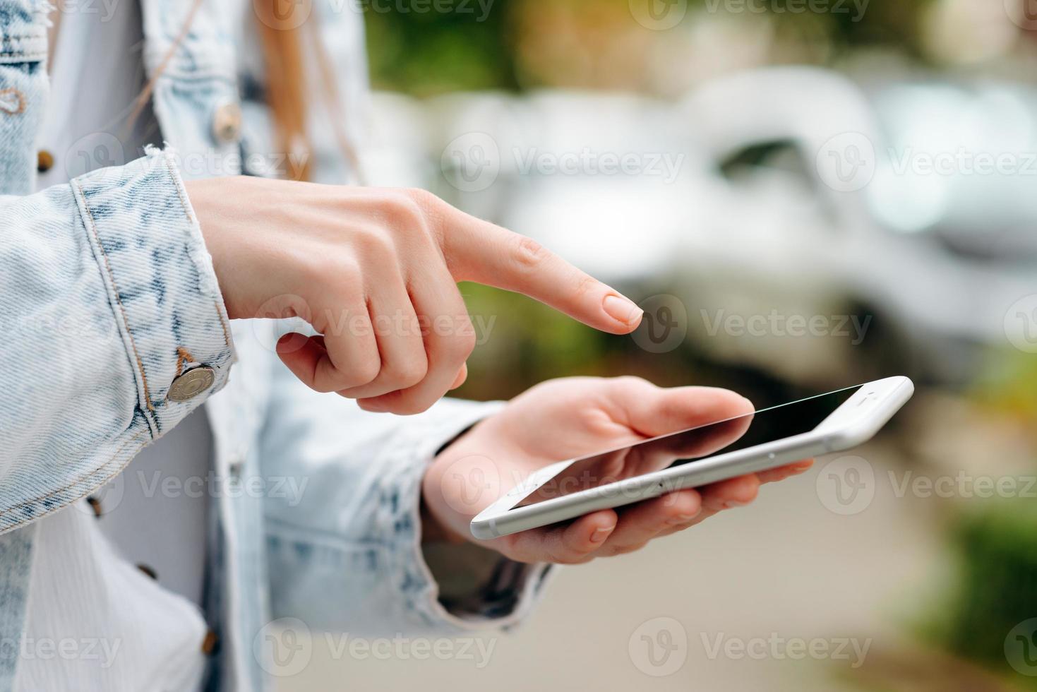 closeup mão feminina com um smartphone. dedo indicador apontando para a tela.- imagem foto
