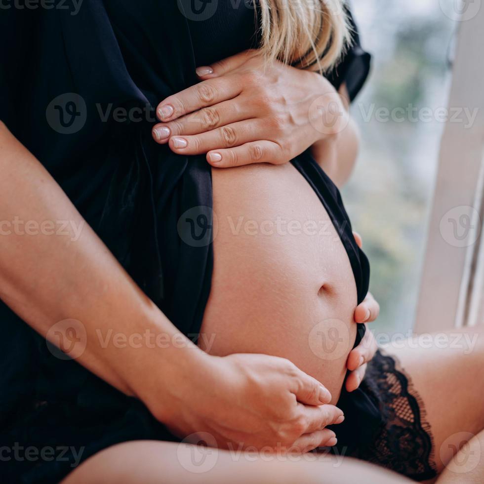 uma mulher grávida abraça a barriga dela foto