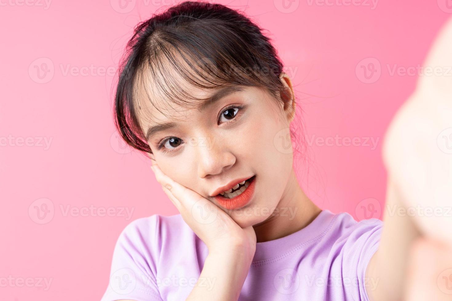 retrato de jovem asiática em fundo rosa foto