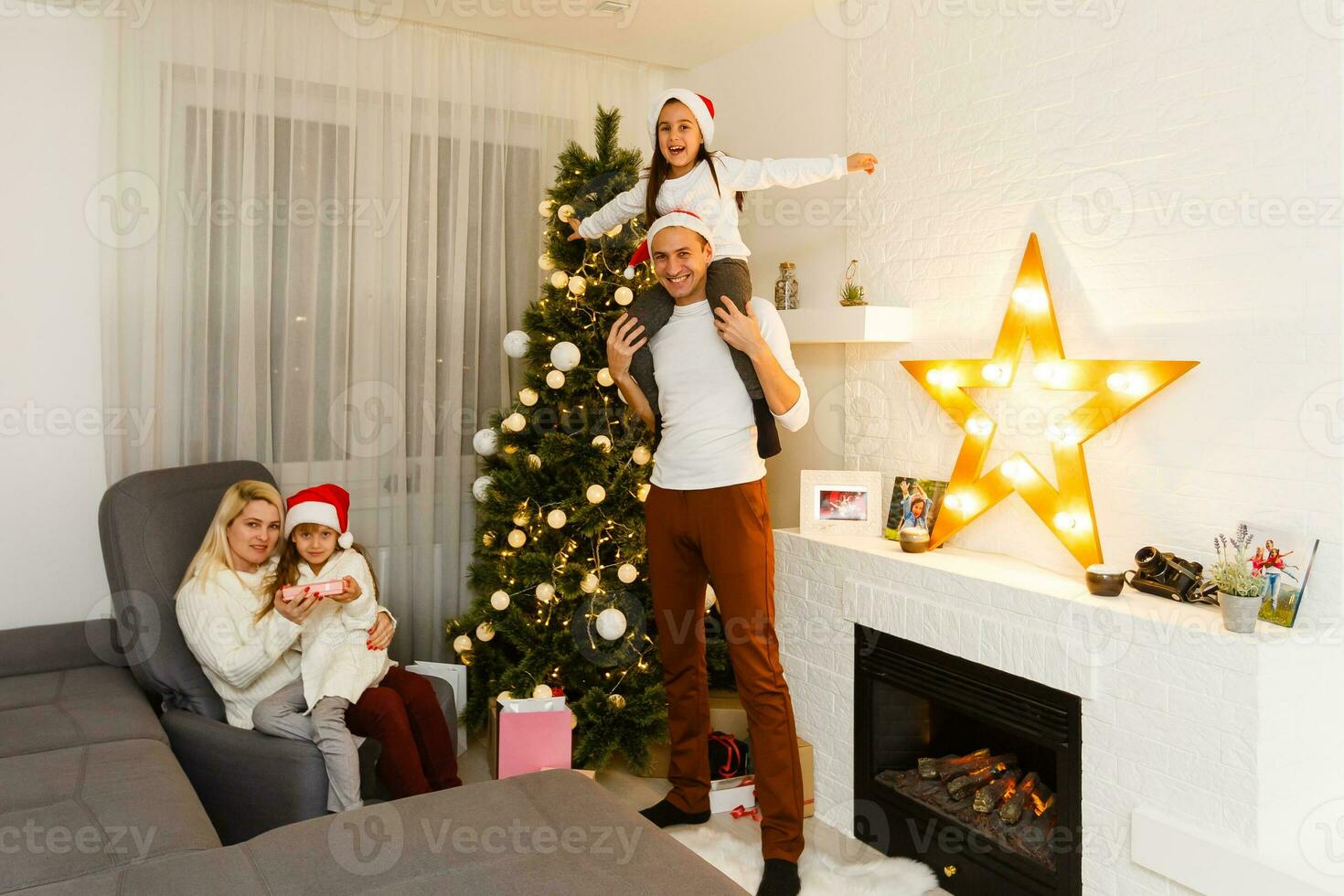 feliz família pai mãe e crianças sentado de lareira em Natal véspera foto