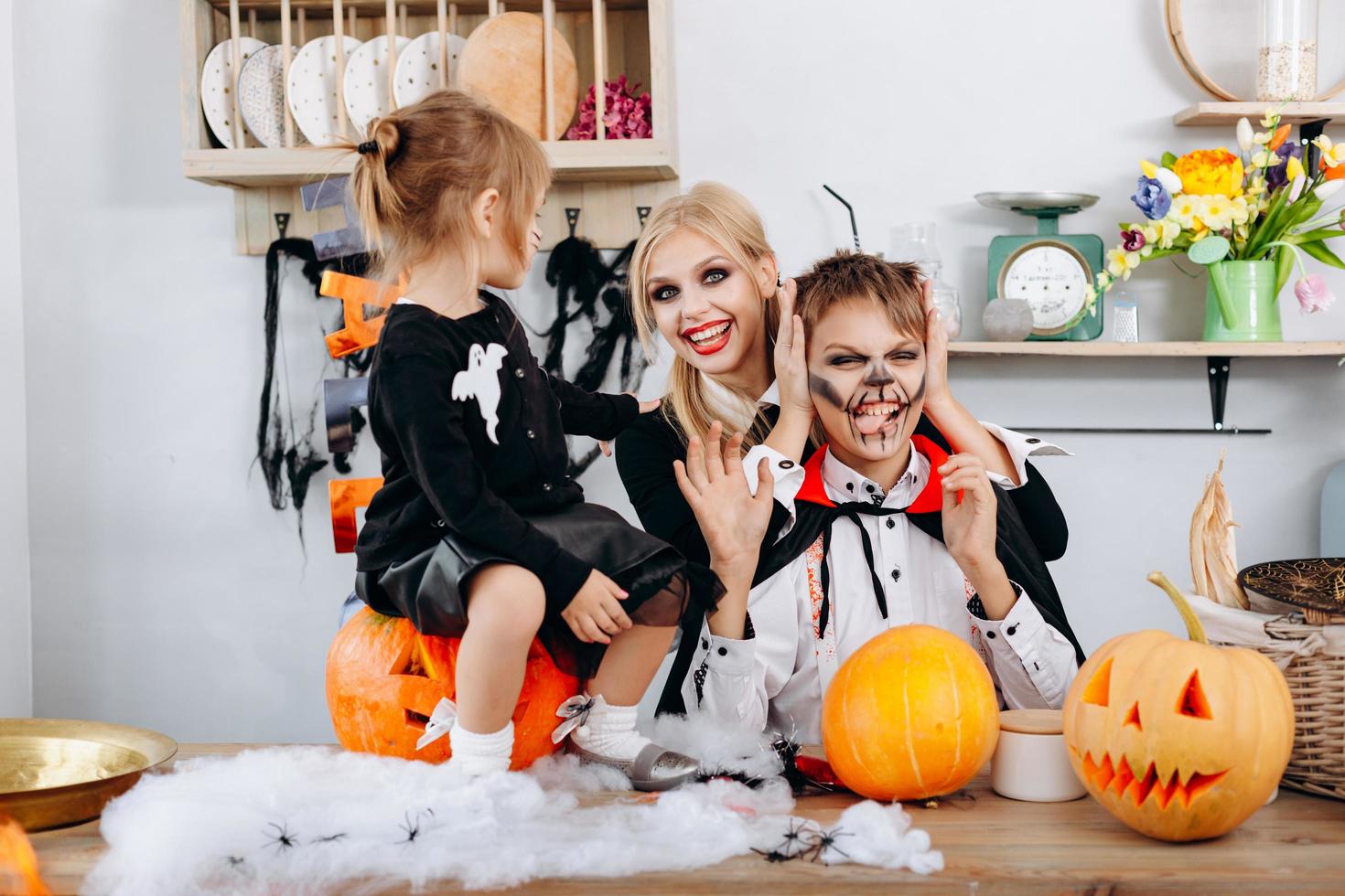 preparações de família felizes para o dia das bruxas. menino mostrando língua e mulher sorrindo foto