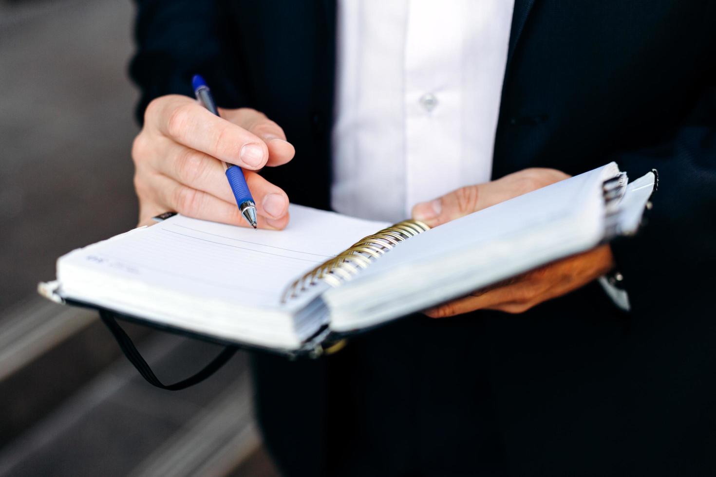 closeup mão masculina com uma caneta e um caderno. escreveu uma nota. - imagem foto