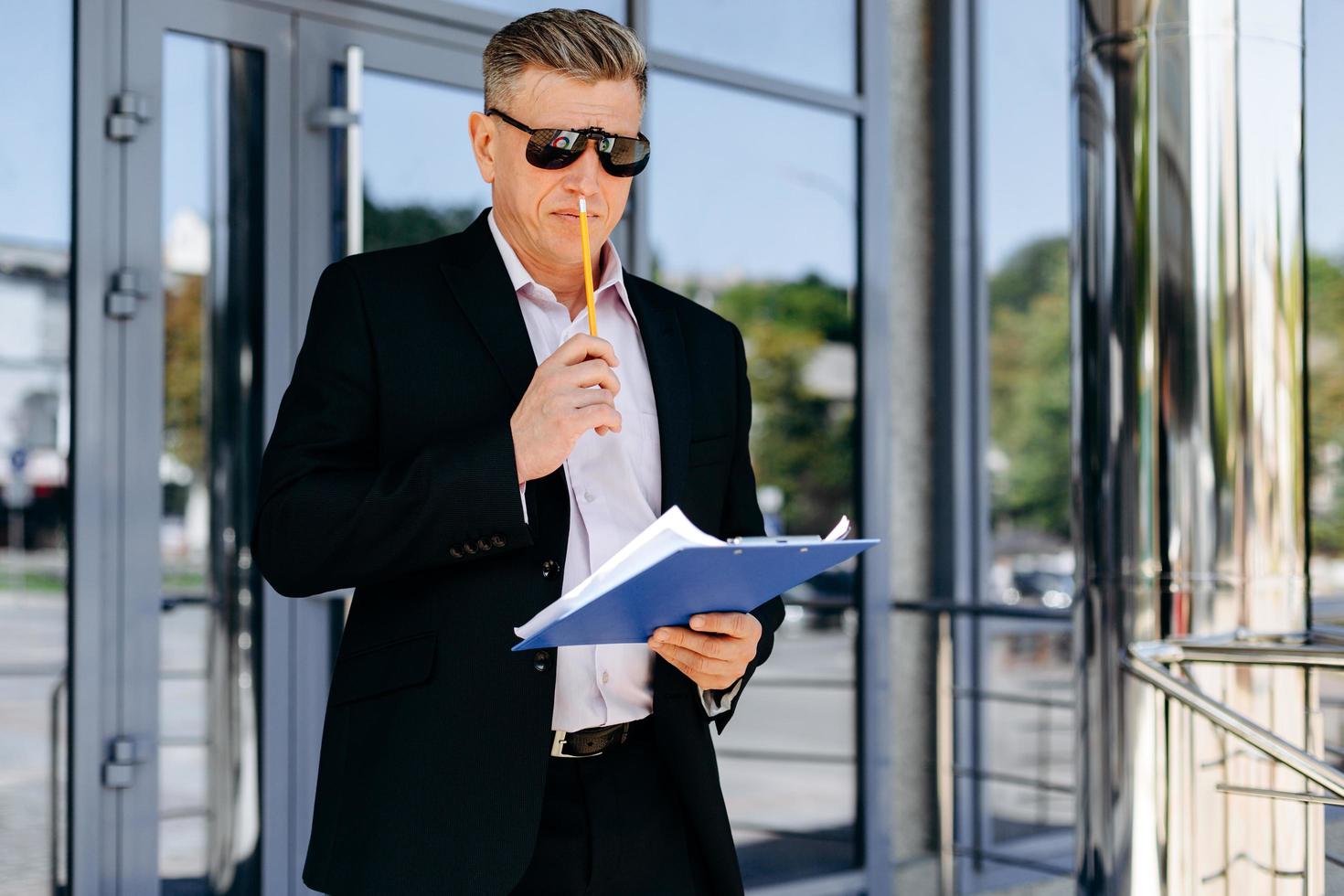 retrato do empresário sênior segurando um documento e pensando. - imagem foto