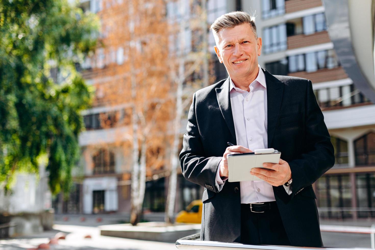 retrato de feliz empresário sênior escrever uma nota e olhando para a câmera. - imagem foto