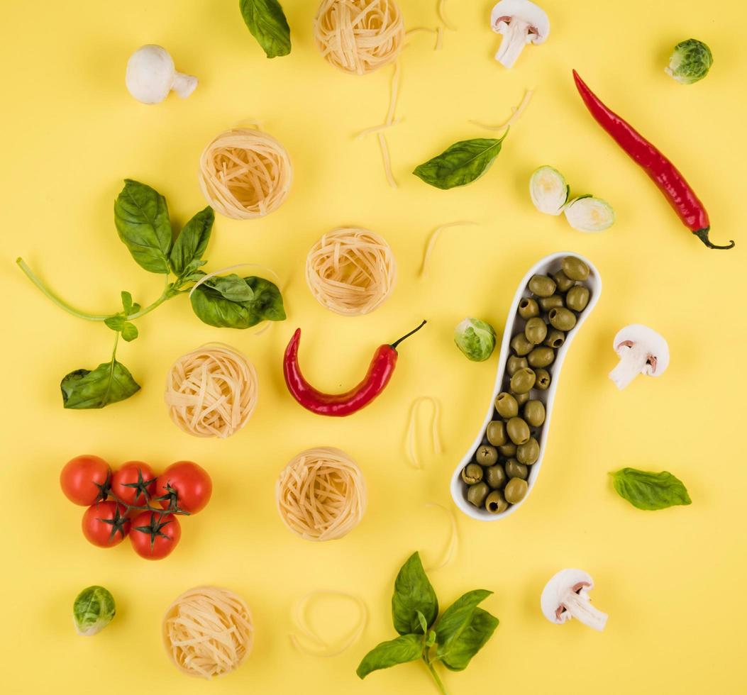 vista superior, deliciosos ingredientes dispostos em fundo amarelo. conceito de cozinhar comida italiana foto
