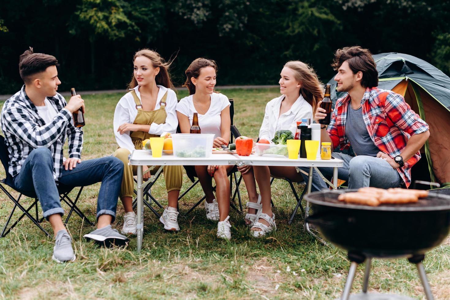 uma companhia de amigos almoça no acampamento foto