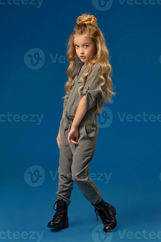 pequeno menina com uma grandes encaracolado cabelo dentro uma elegante roupas foto