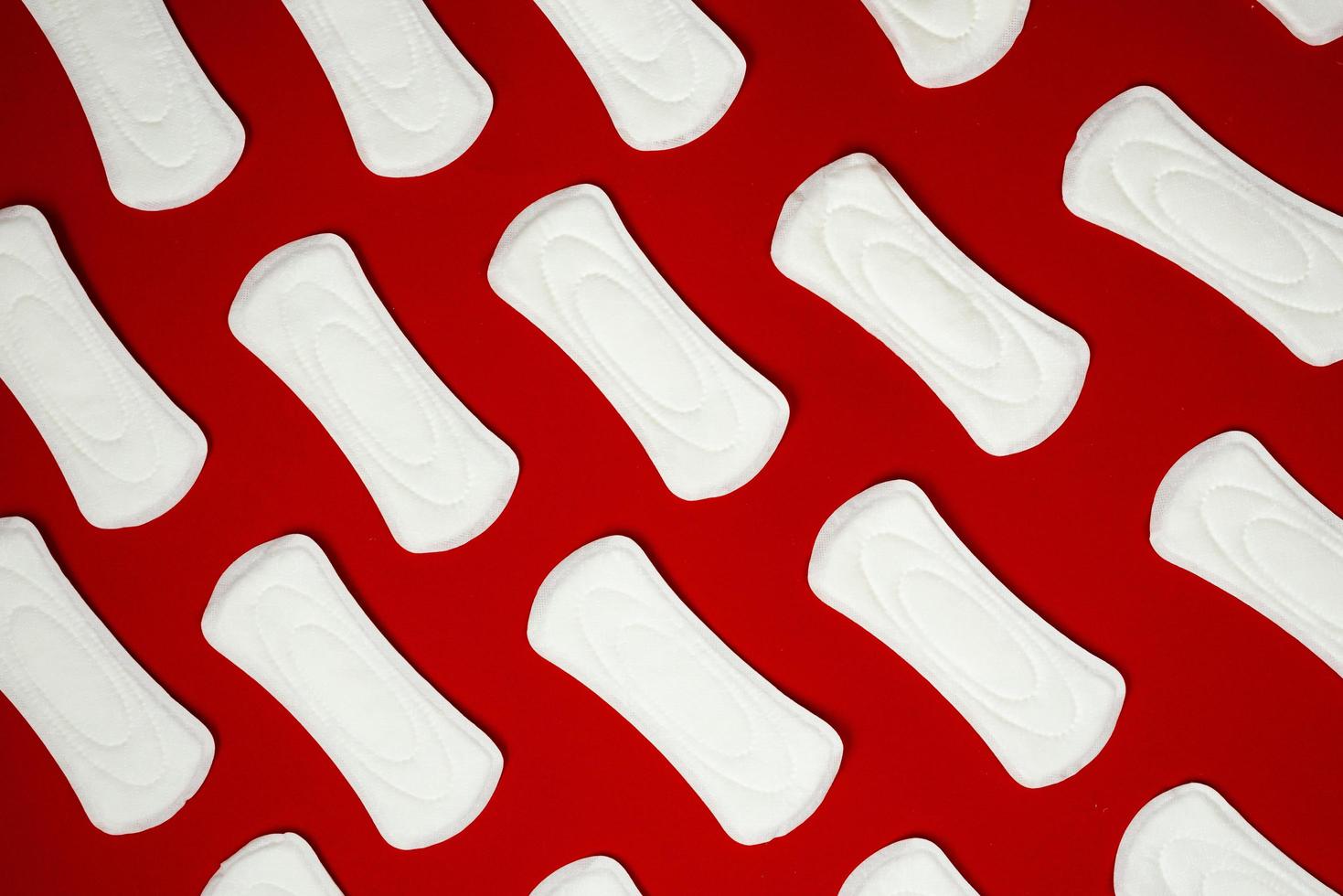 almofadas femininas higiênicas sobre fundo vermelho, menstruação. foto