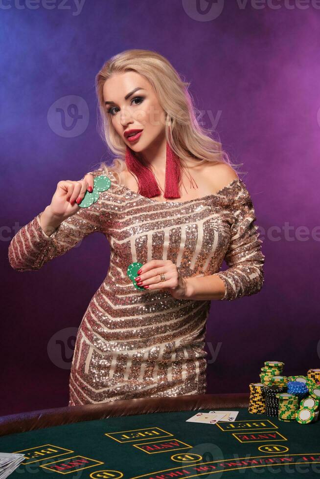 Loiras mulher com uma perfeito Penteado e brilhante Maquiagem é posando com jogos de azar salgadinhos dentro dela mãos. cassino, pôquer. foto