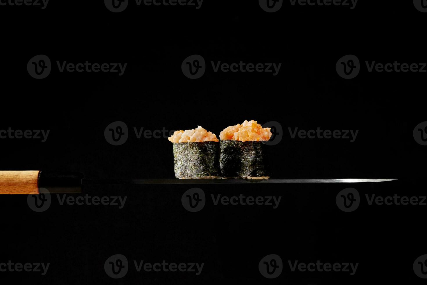 gunkan maki com cobertura do cru salmão e vermelho tobiko em fino lâmina do japonês faca foto