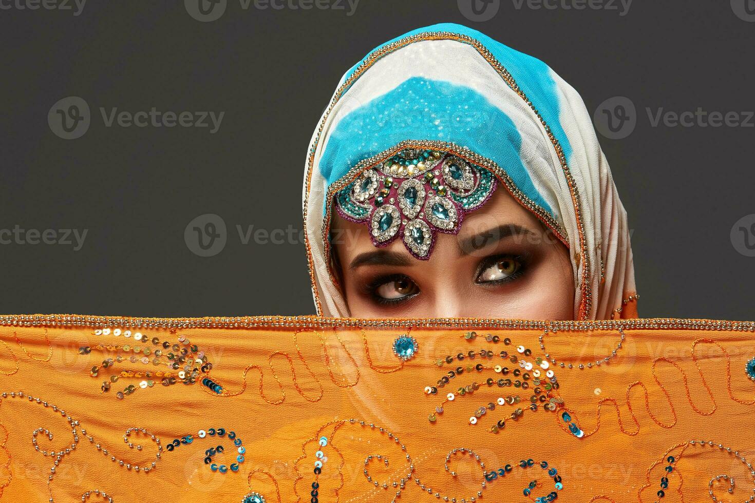 estúdio tiro do uma cromo fêmea vestindo a colorida hijab decorado com lantejoulas e joia. árabe estilo. foto