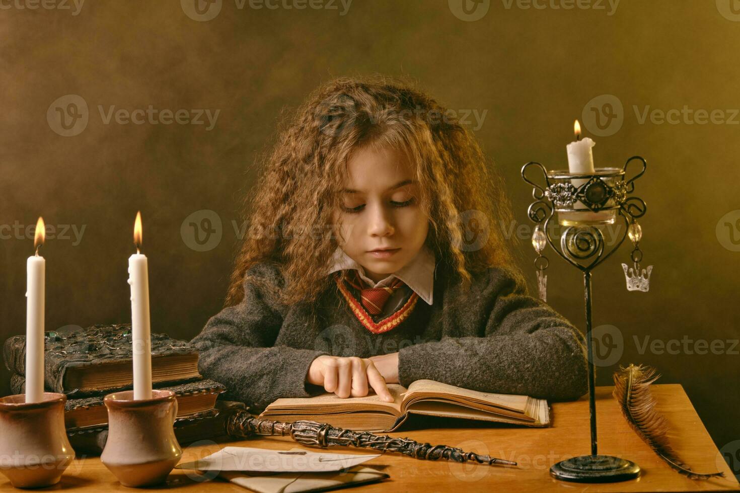 pequeno bruxa vestido dentro Sombrio roupas sentado às a mesa contra Preto esfumaçado fundo e lendo uma livro. fechar-se retrato. foto