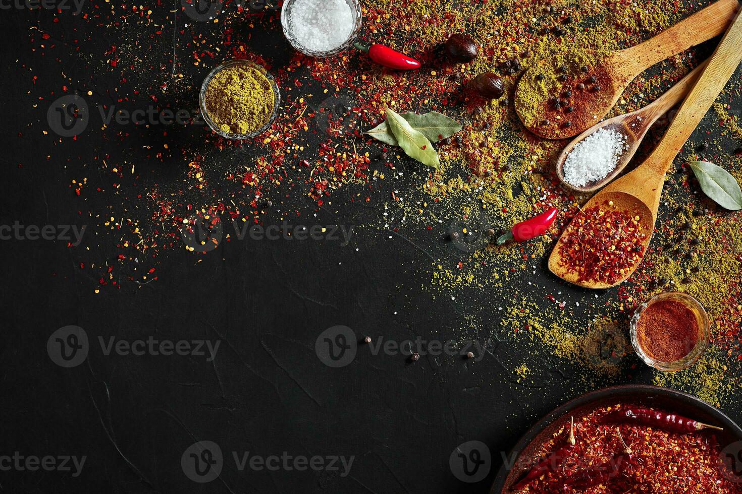 sortido especiarias em Sombrio Preto fundo. temperos para Comida. Curry, páprica, pimenta, cardamomo, cúrcuma. topo visualizar. foto