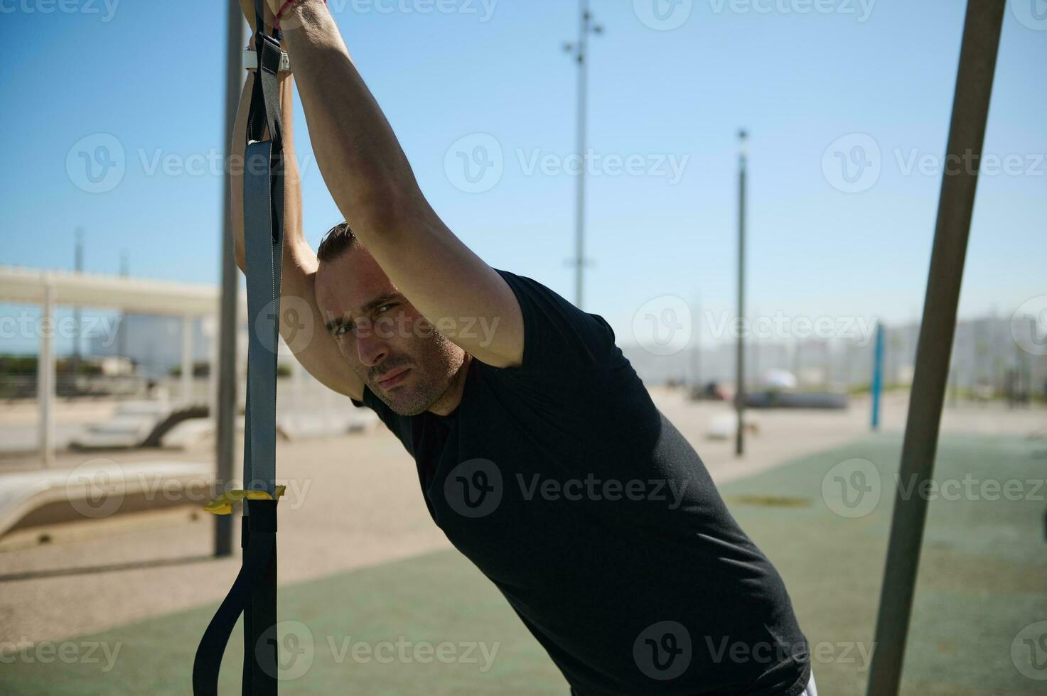 fechar-se retrato do desportista relaxante durante ao ar livre exercite-se com suspensão correias, olhando com confiança às a Câmera foto