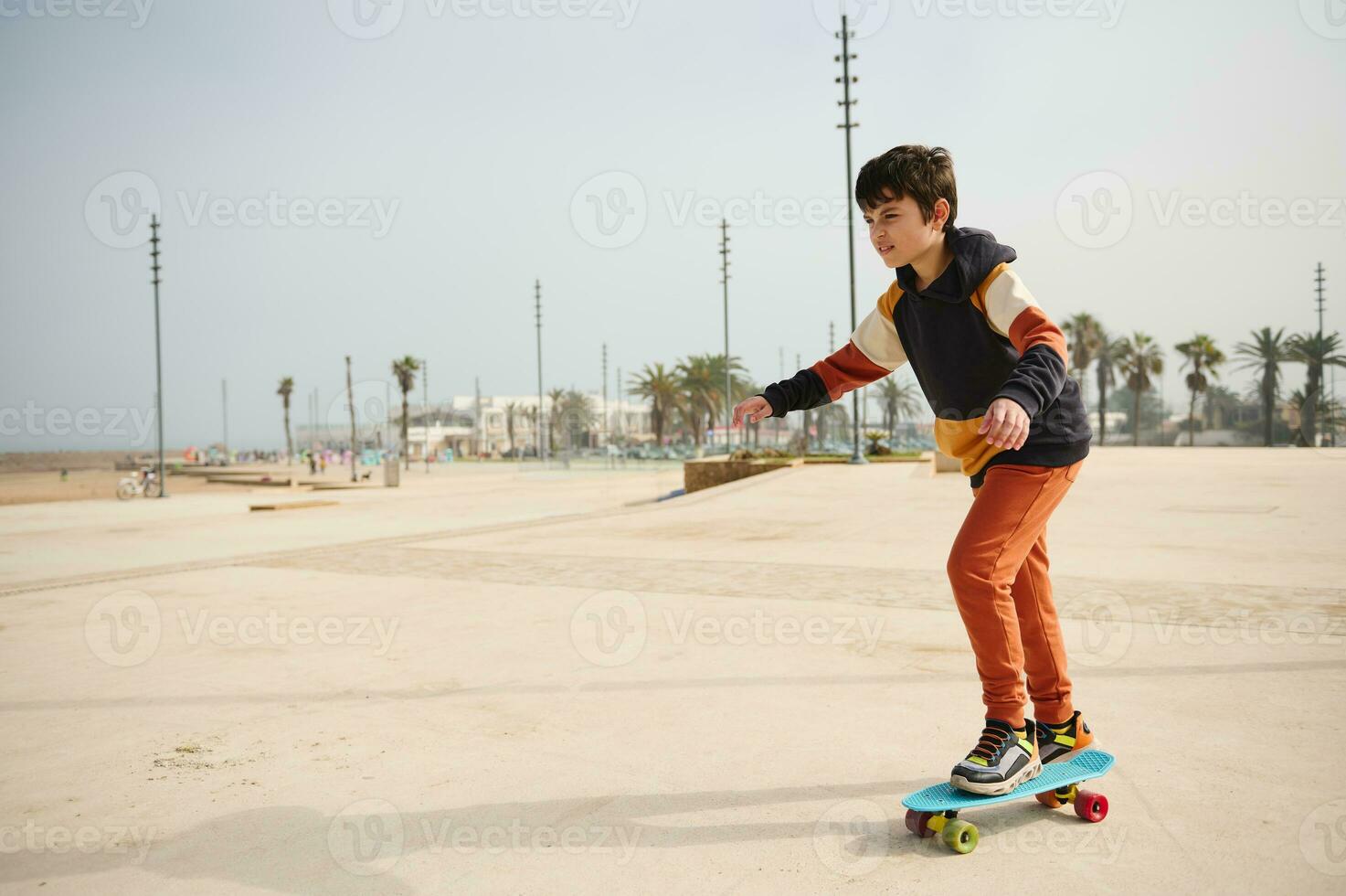 feliz ativo Adolescência Garoto equitação em skate em a urbano Parque de skate Parque infantil, vestido dentro à moda roupa de esporte. foto