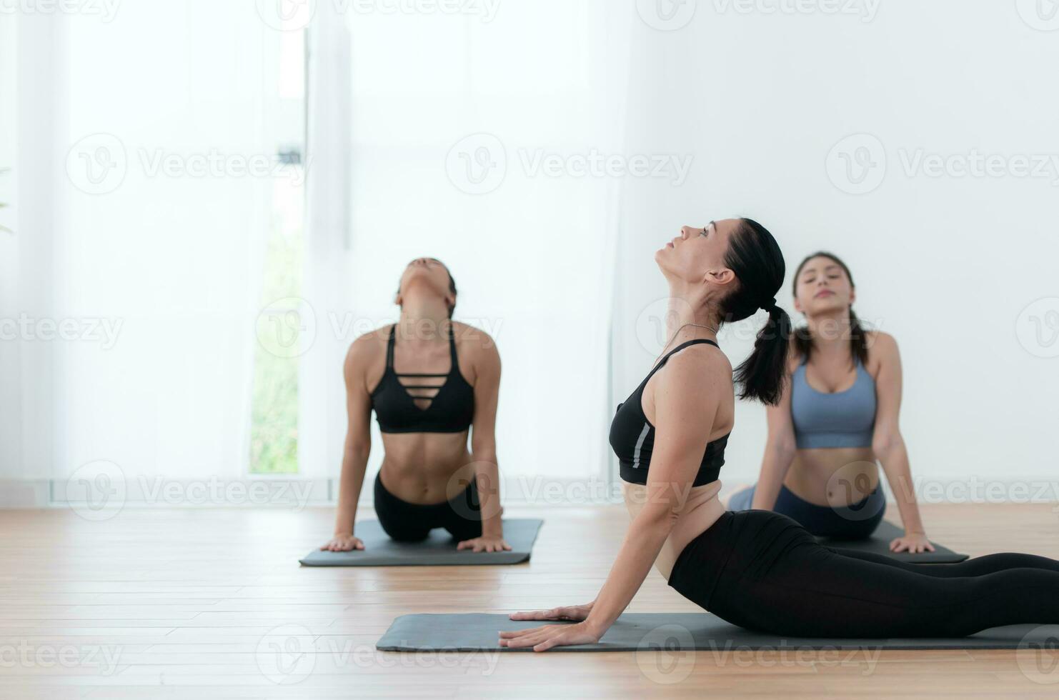 grupo do pessoas praticando ioga dentro uma estúdio. ioga classe conceito. foto