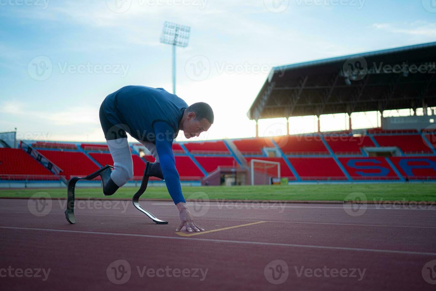 Desativado atletas preparar dentro iniciando posição pronto para corre em estádio rastrear foto