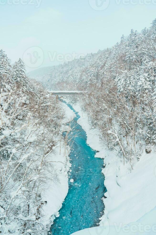 Shirahige cascata com neve dentro inverno, biei rio fluxo para dentro azul lago. ponto de referência e popular para atrações dentro Hokkaido, Japão. viagem e período de férias conceito foto