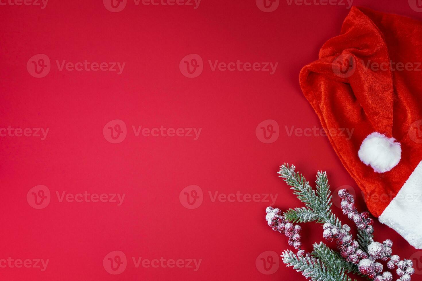 vermelho santa claus chapéu e Natal árvore ramo em vermelho fundo foto