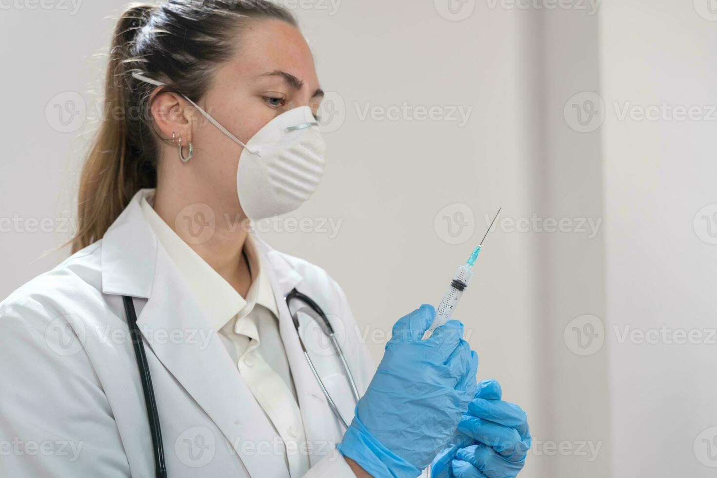 jovem atraente fêmea médico preparando vacina seringa vestindo preventivo mascarar e azul luvas. coronavírus. foto