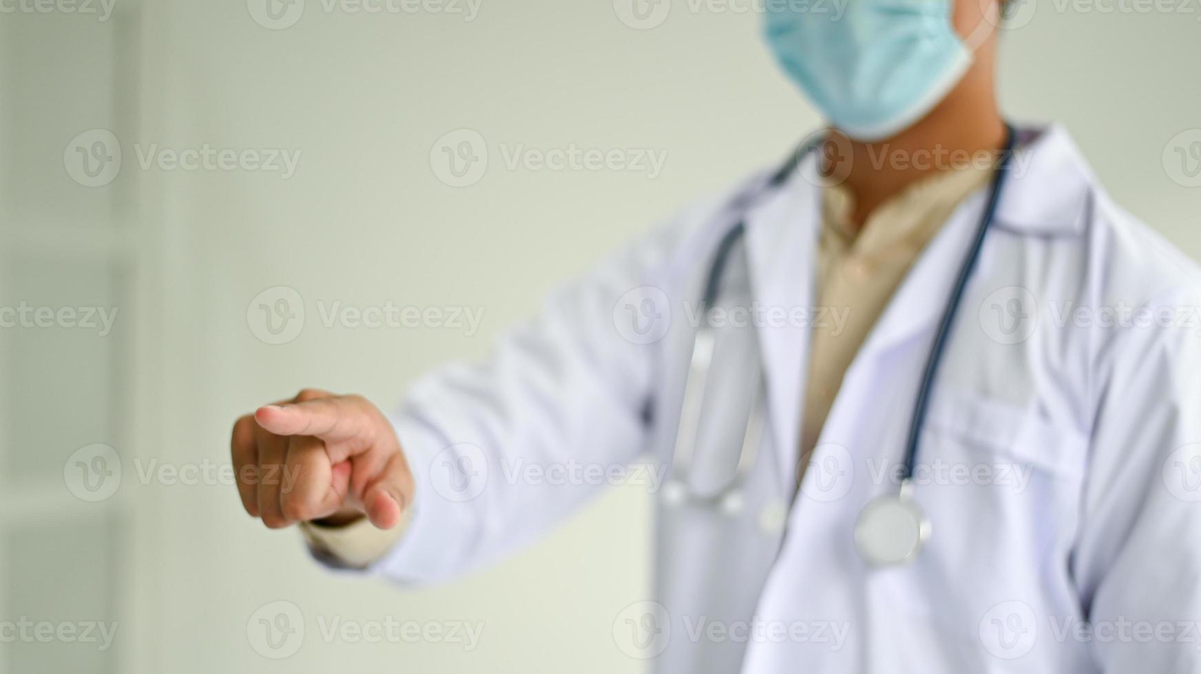 foto cortada de um médico em um uniforme de laboratório, apontando para a frente, conceitos médicos.