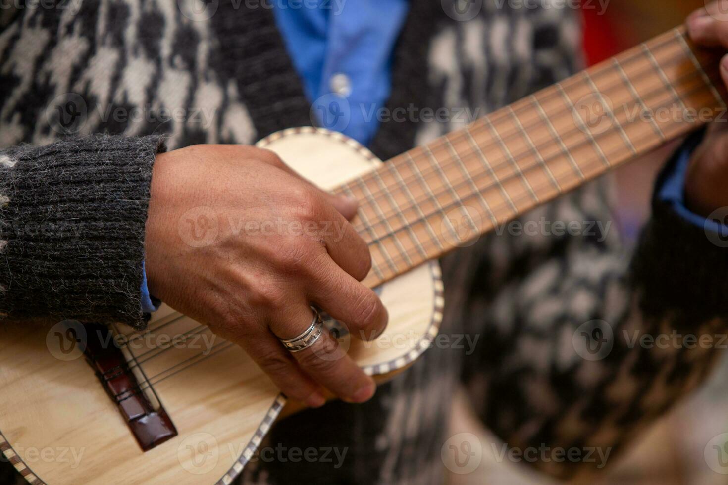 peruano jogando uma miniatura guitarra foto