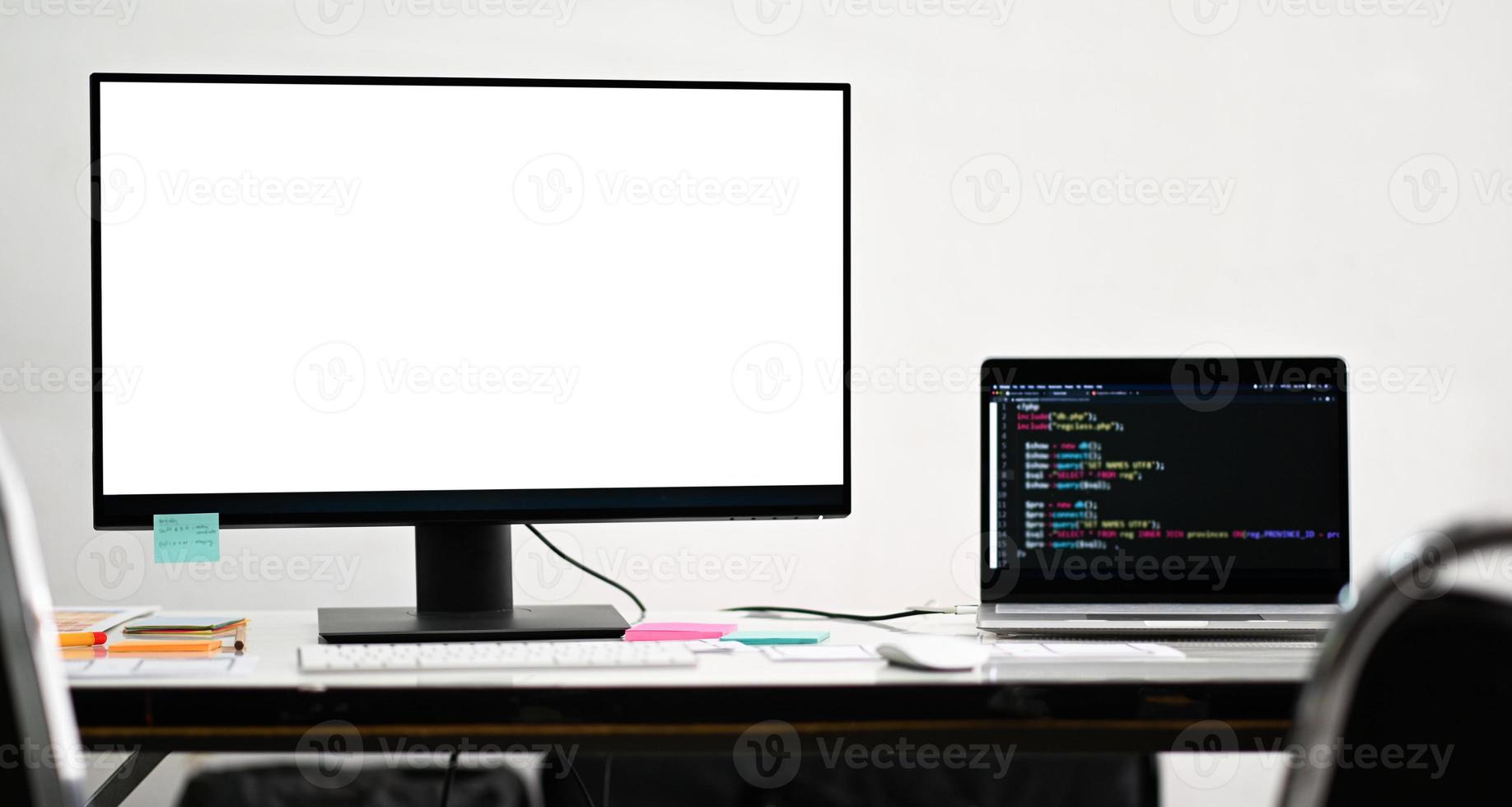 computador de tela em branco de maquete e laptop em uma mesa de programador. foto