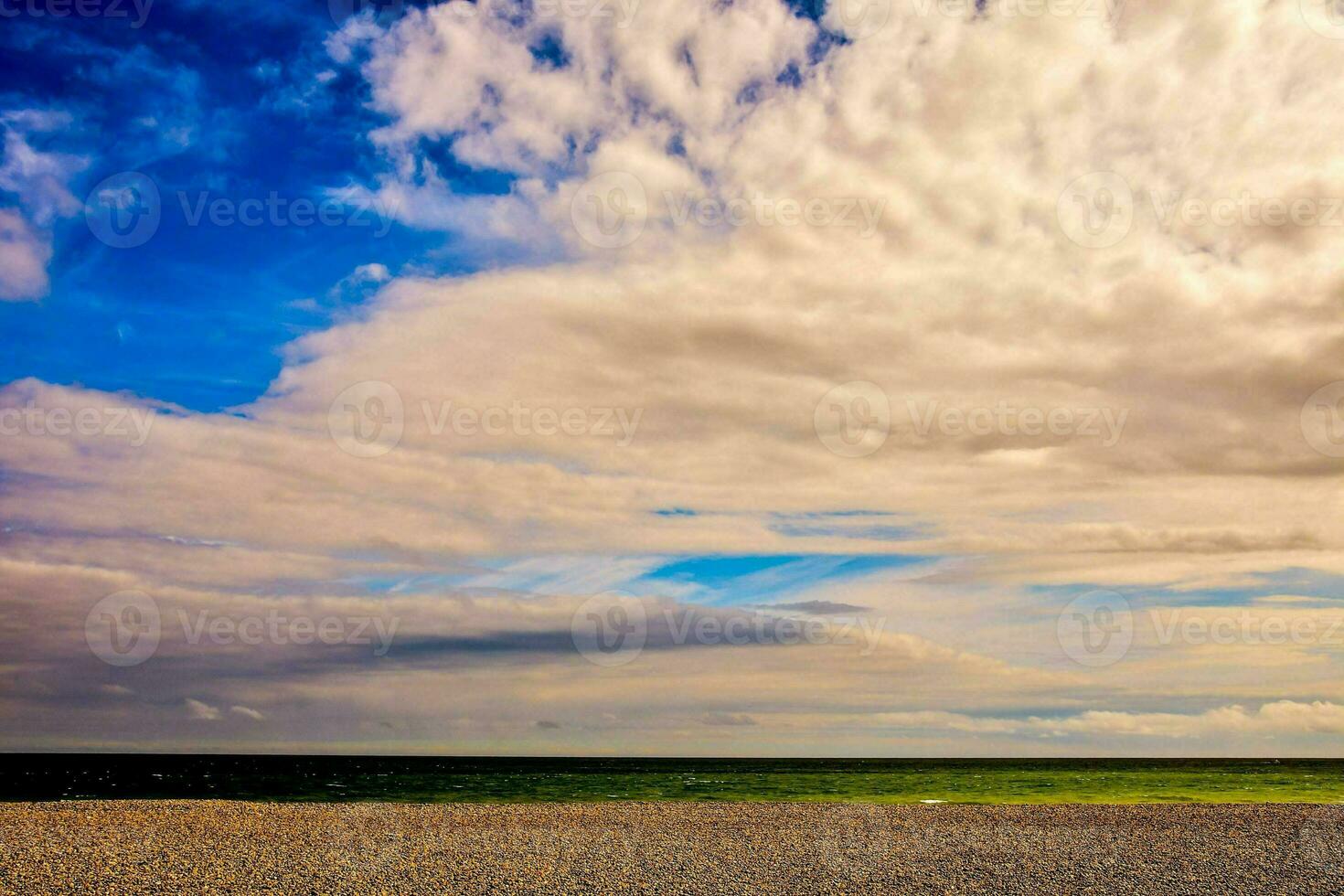 uma de praia com uma nublado céu e uma verde campo foto