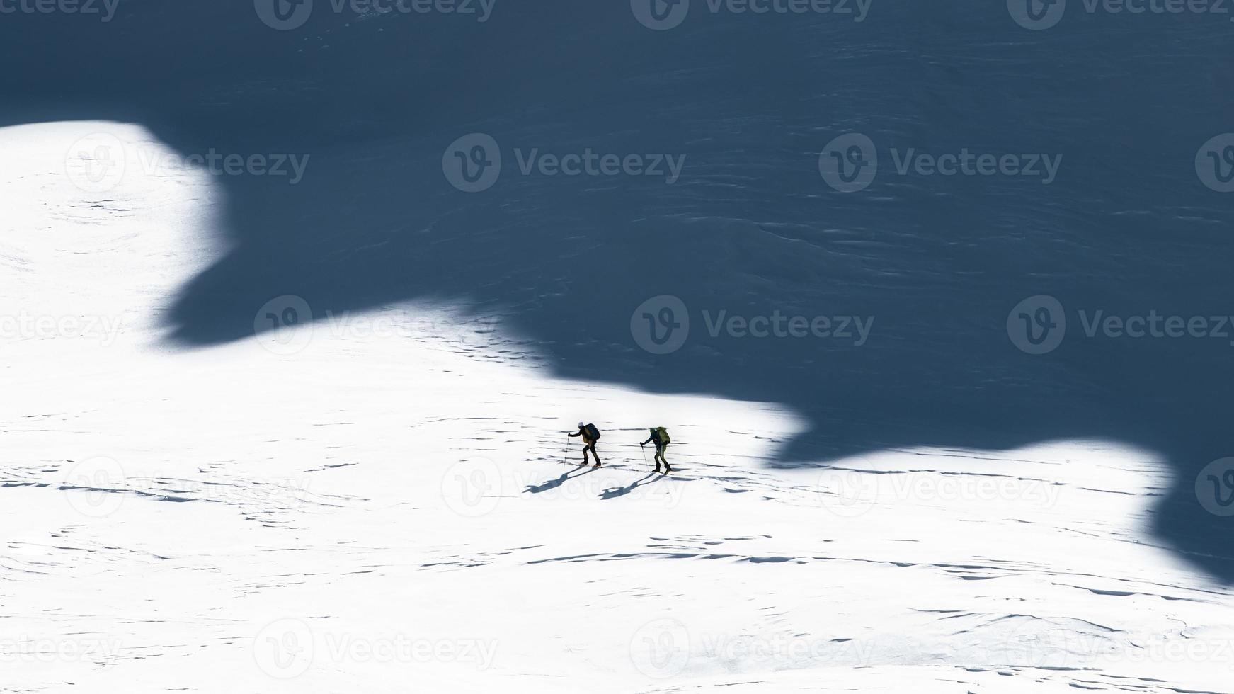 alpinistas de esqui nas sombras das montanhas. foto de estilo artístico