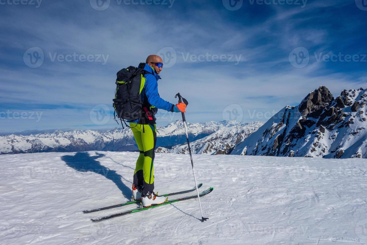 o alpinista de esqui chegou ao topo está pronto para a descida foto